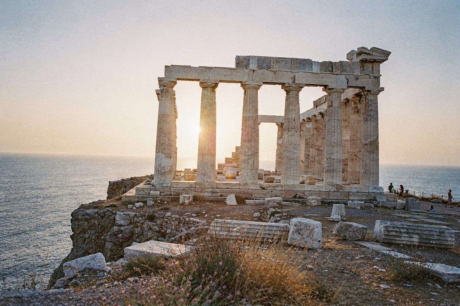The marble columns of the Temple of Poseidon at Cape Sounion at sunset, on a headland above the Aegean