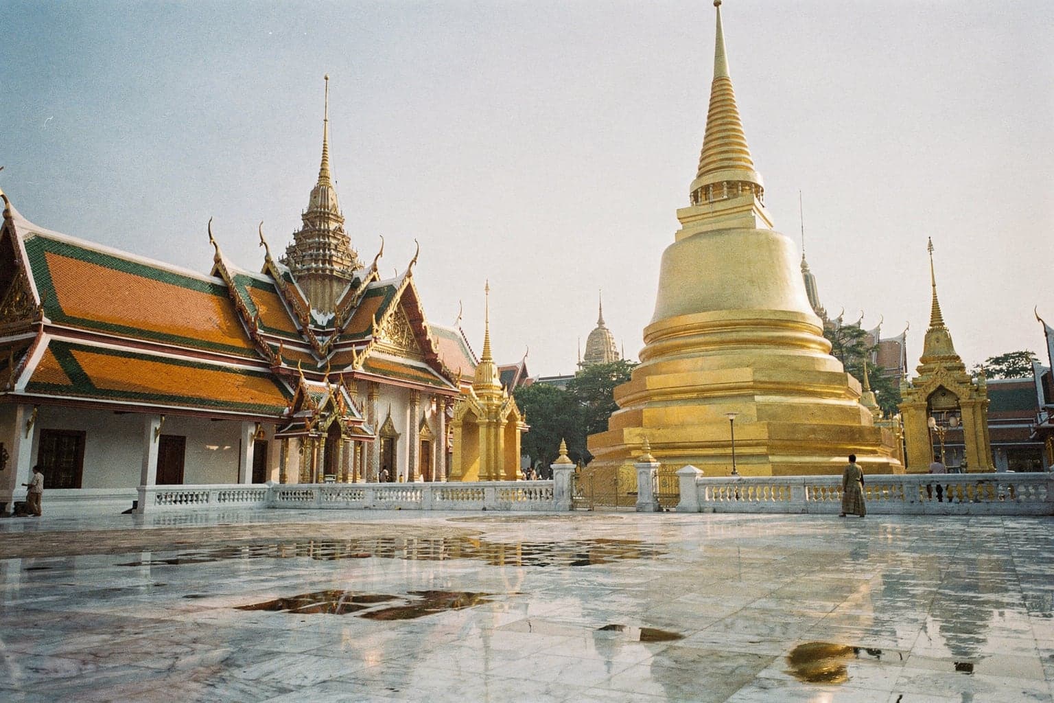 The golden Phra Si Rattana Chedi and gilded spires of Wat Phra Kaew inside the Grand Palace in early-morning light