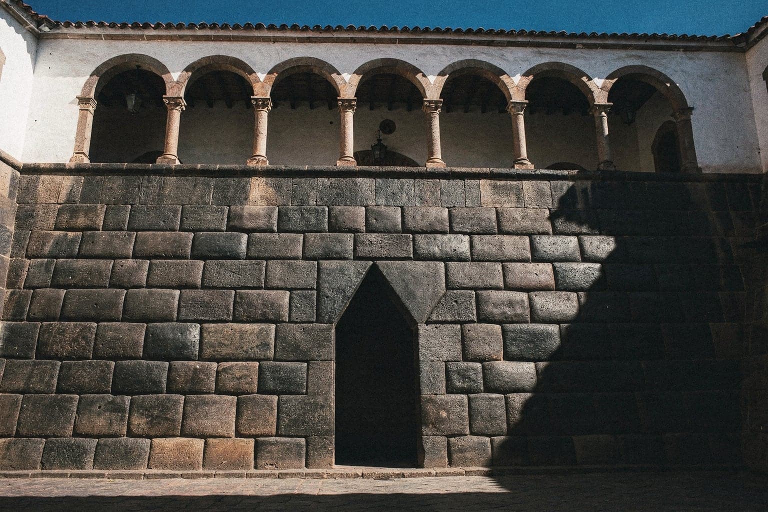 Fitted Inca stone walls and a trapezoidal niche at the Qorikancha, below the arches of the Santo Domingo convent